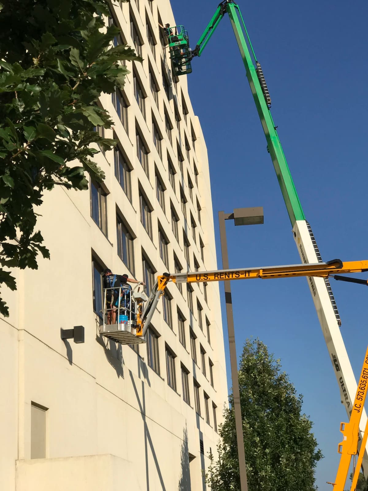 Crew on a lift washing the upper floors of a high-rise building