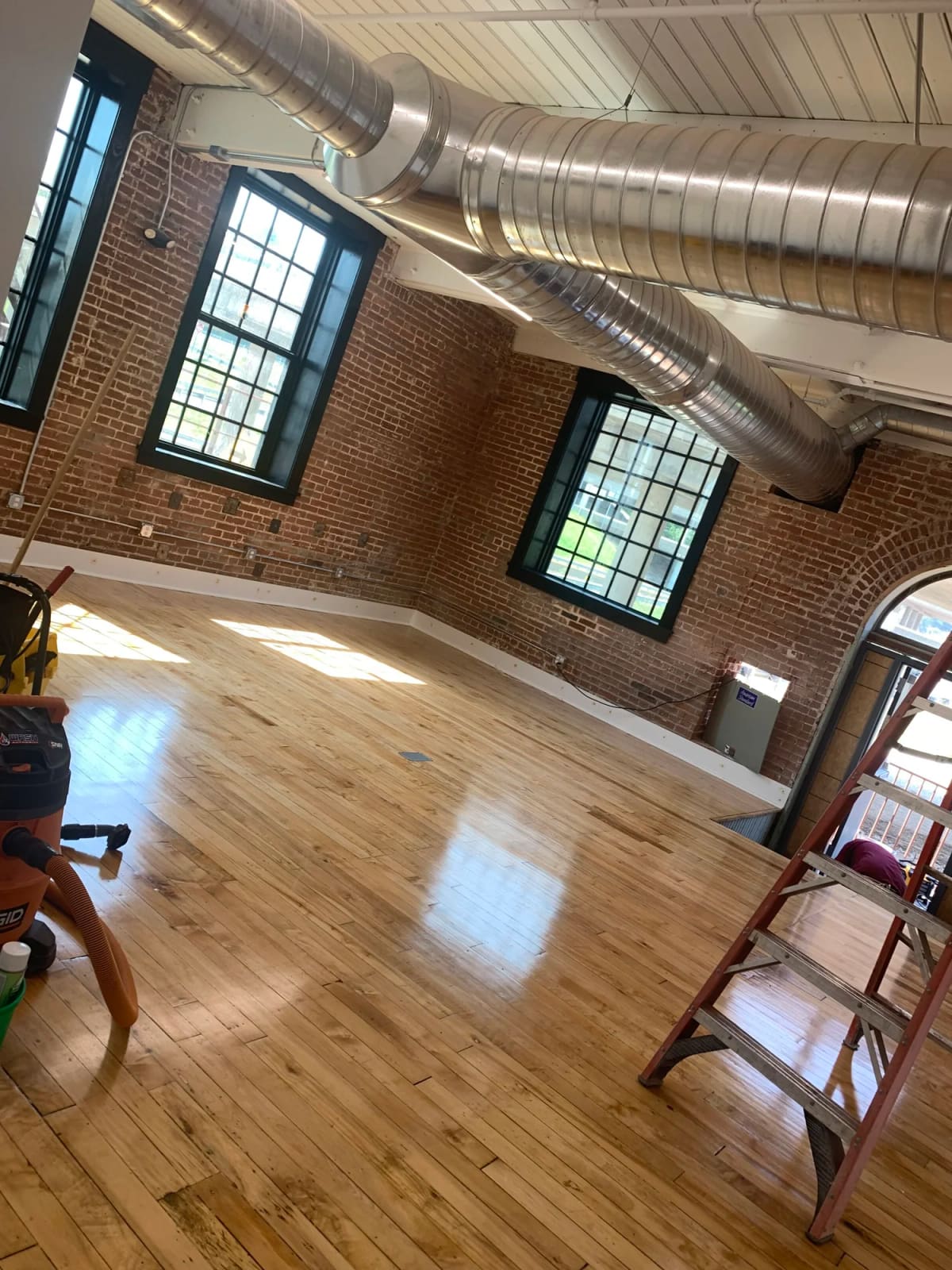 Polished wood floors in a brick loft space after a post construction final clean